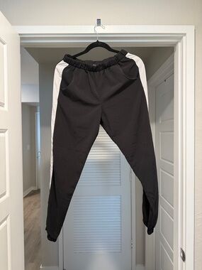 happening in the present Black Track Pants with White Side Panels